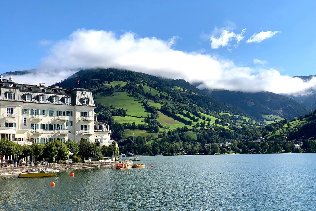 a lake with mountains in the background and a building in the foreground
