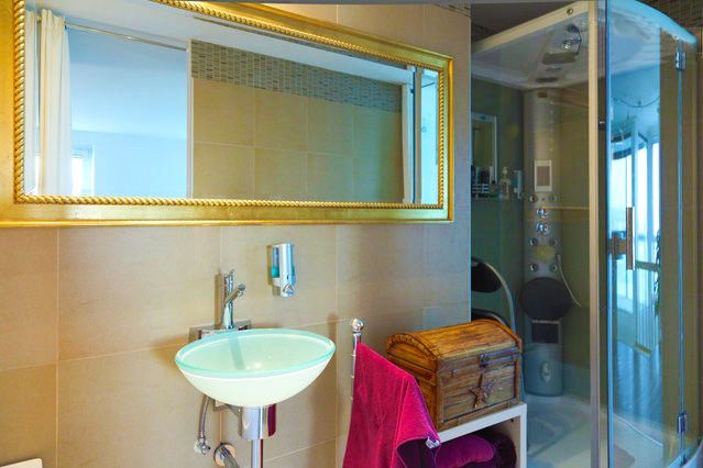 a bathroom with a sink, mirror and shower