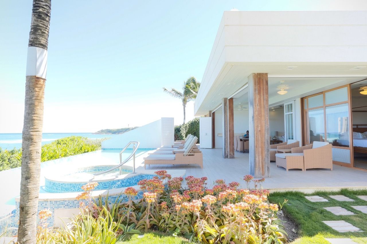 a large white house with a swimming pool and a view of the ocean