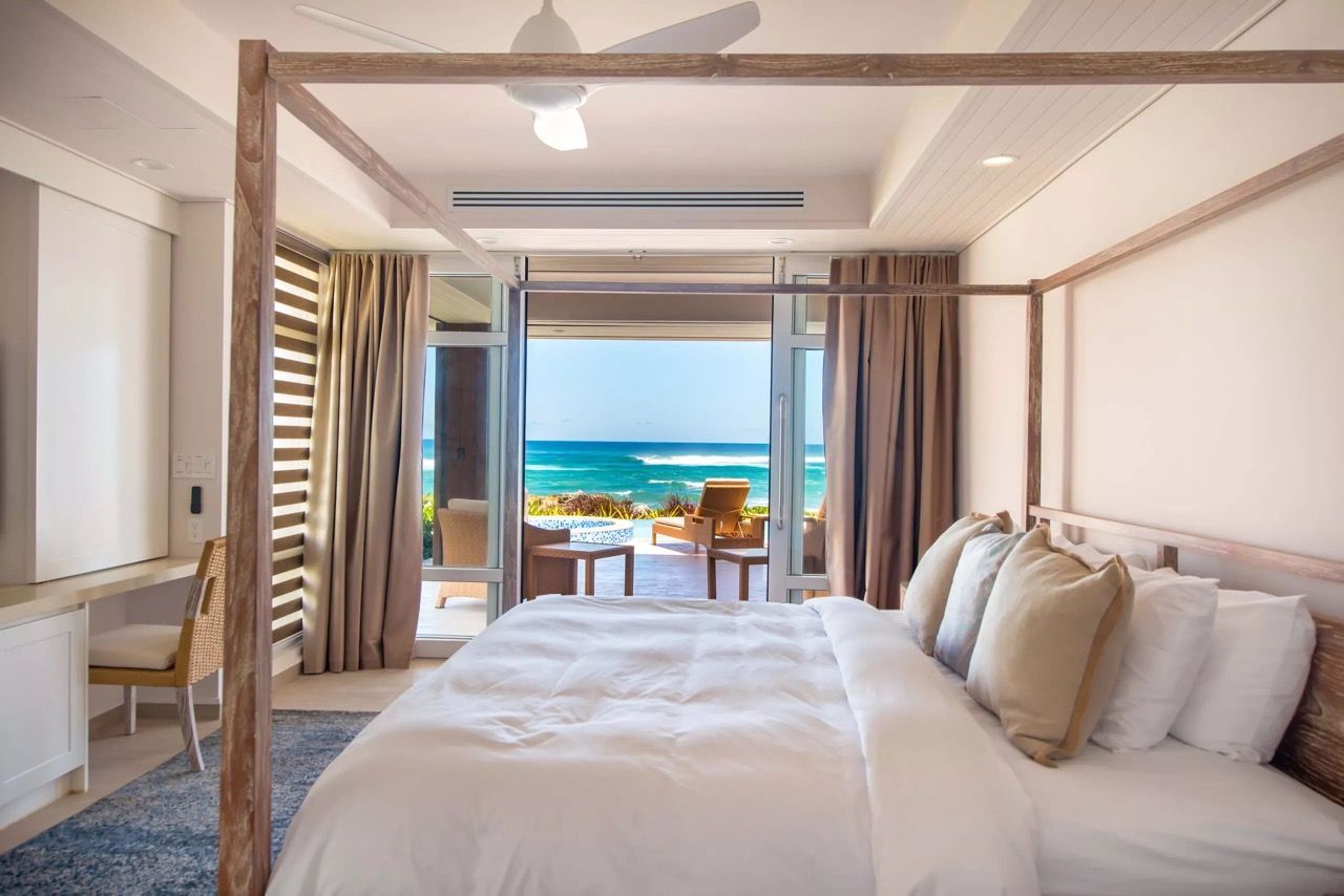 a bedroom with a canopy bed and a view of the ocean