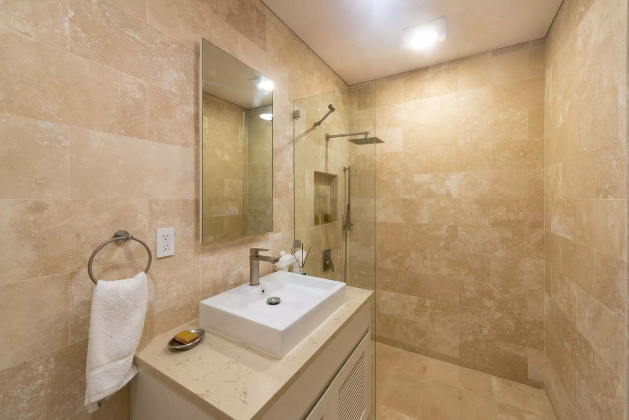 a bathroom with a sink , mirror and walk in shower
