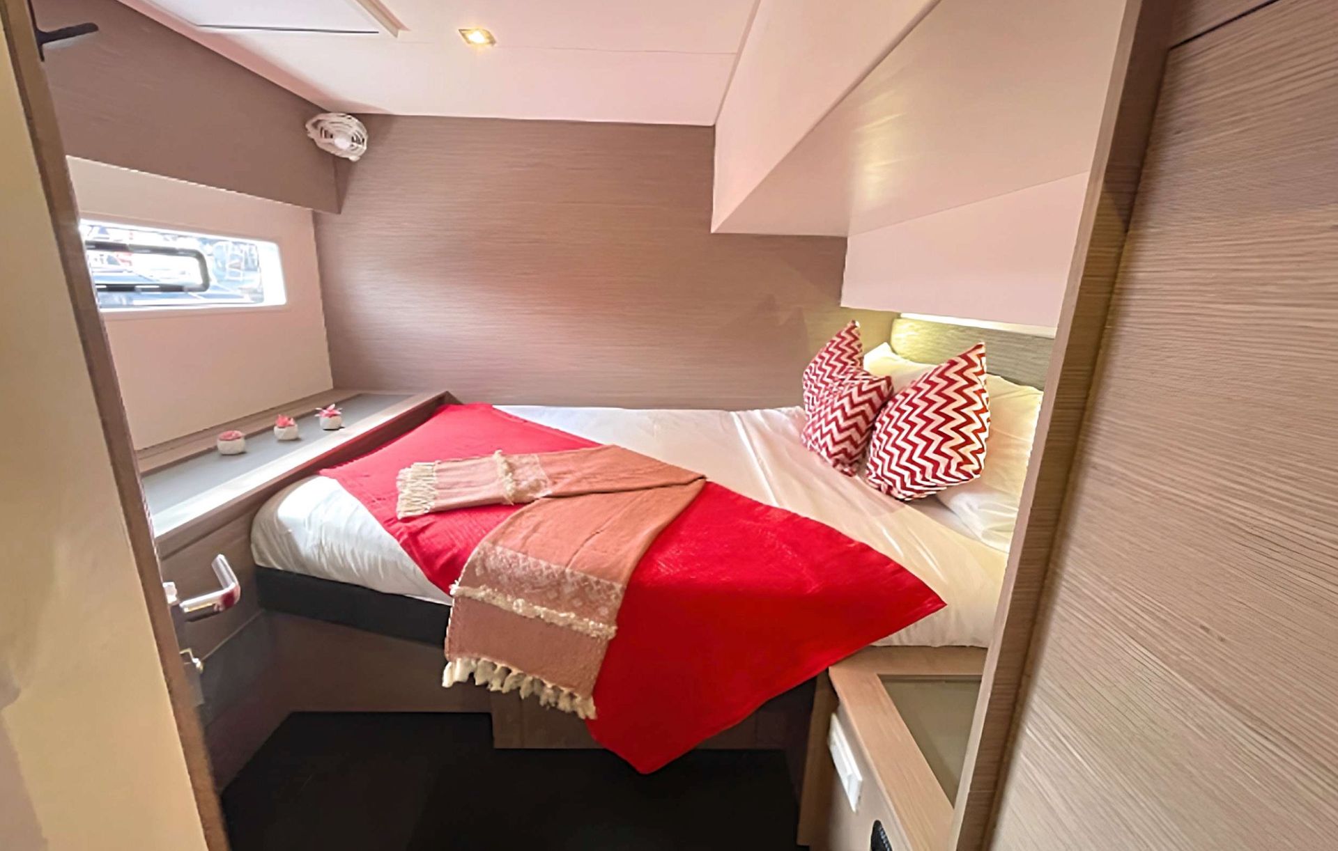 a bedroom on a boat with a bed and a window