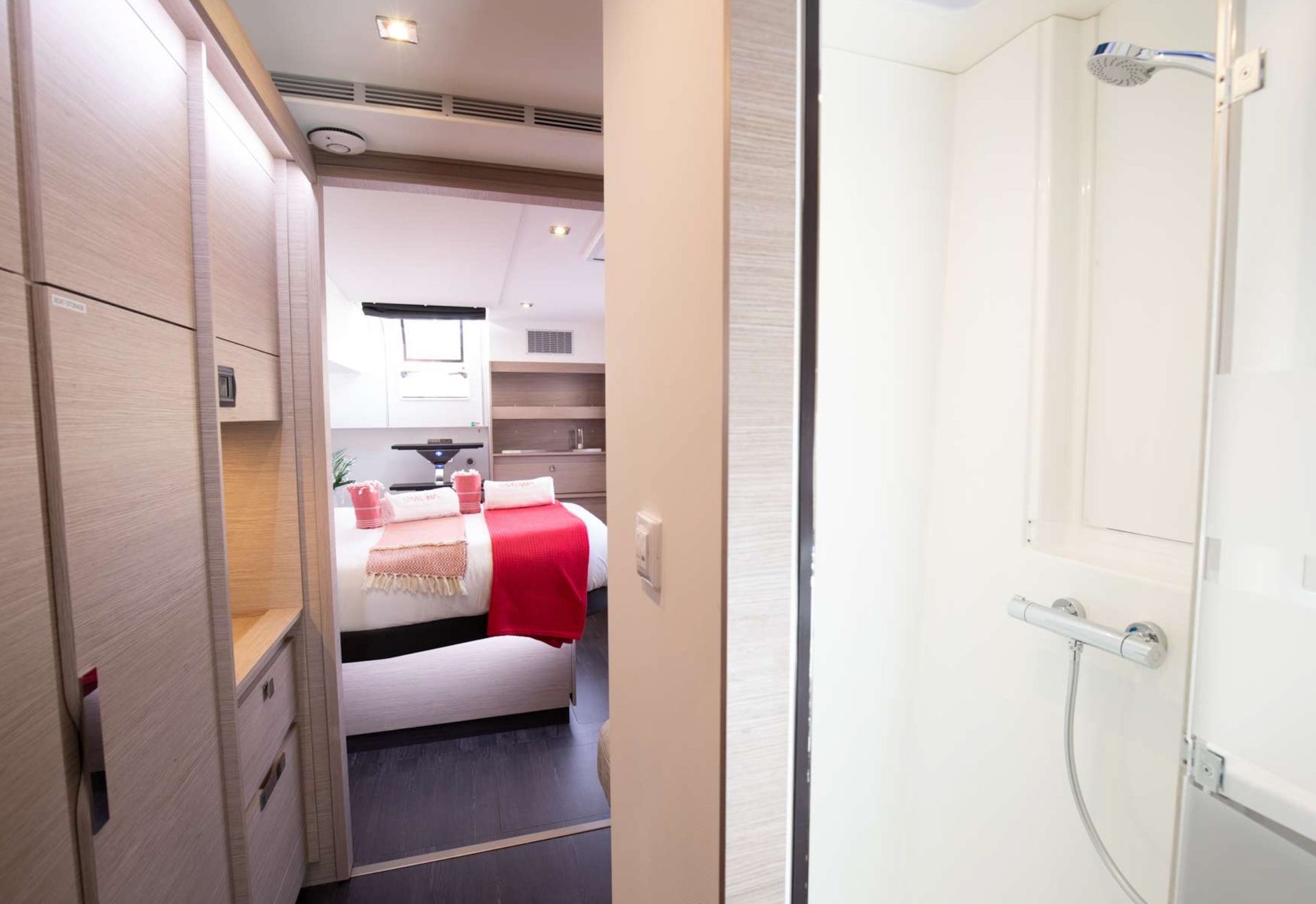 a bathroom with a shower and a bed in the background