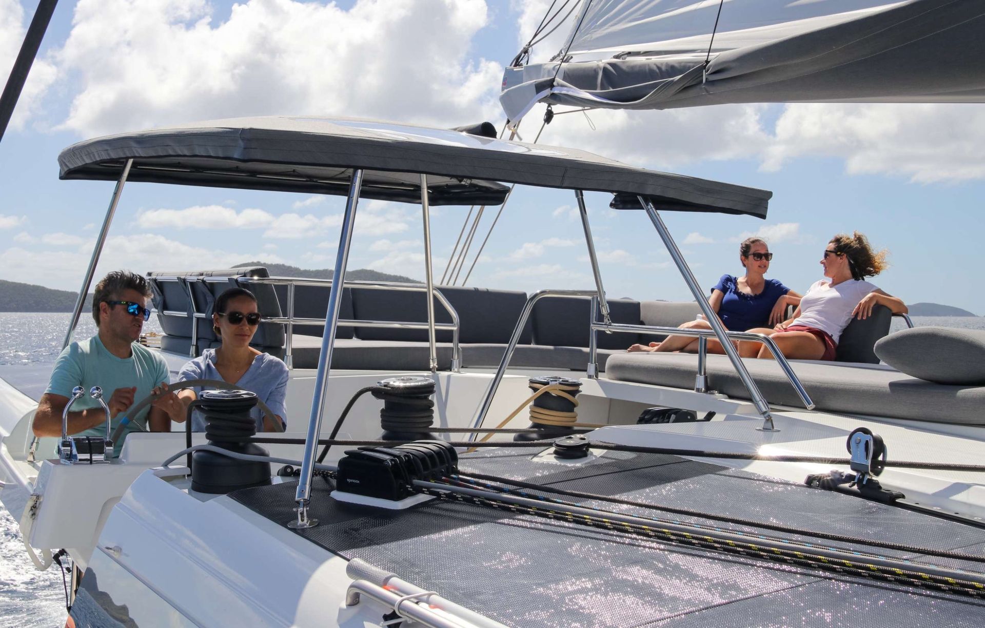 a group of people are sitting on the deck of a sailboat