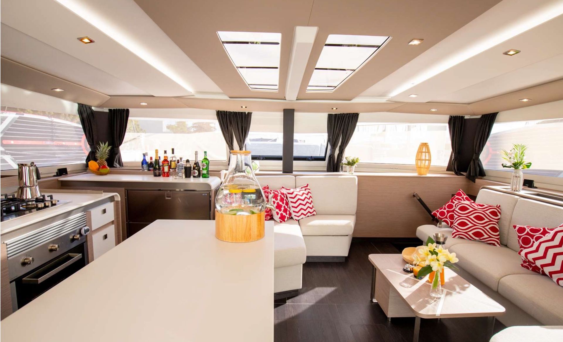 a living room on a boat with a couch, table and kitchen