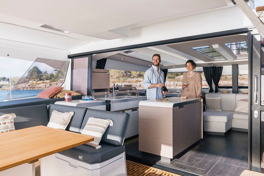 a man and a woman are standing in a living room on a boat
