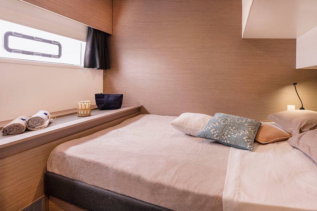 a bedroom on a boat with a bed and a window .