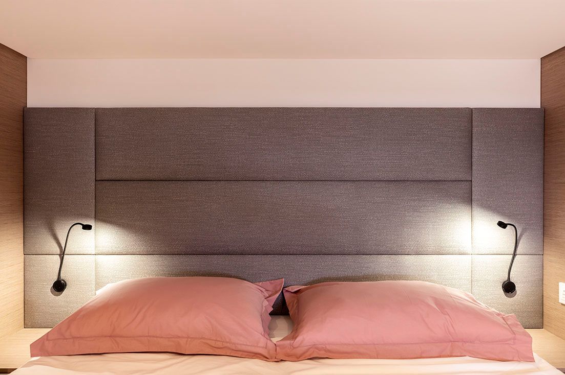 a bed with pink pillows and a headboard in a bedroom .