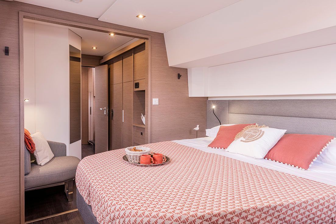a bedroom on a boat with a large bed and a chair .
