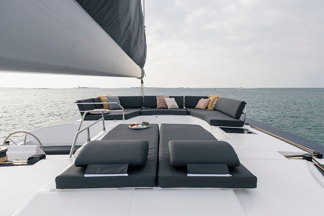 there is a couch on the deck of a sailboat in the ocean