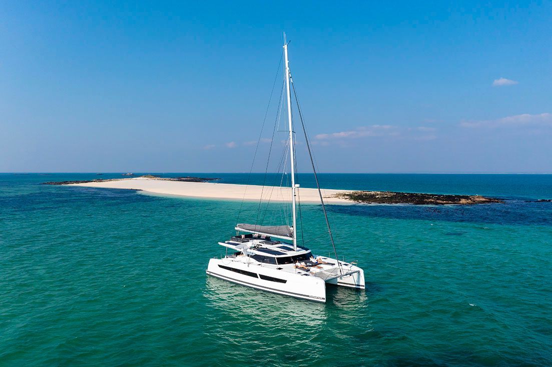 a sailboat is floating in the ocean near a small island
