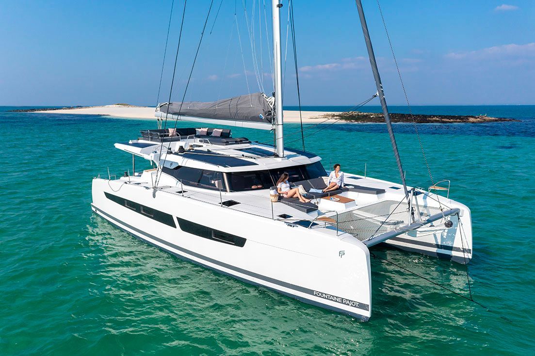 a white sailboat is floating on top of a body of water