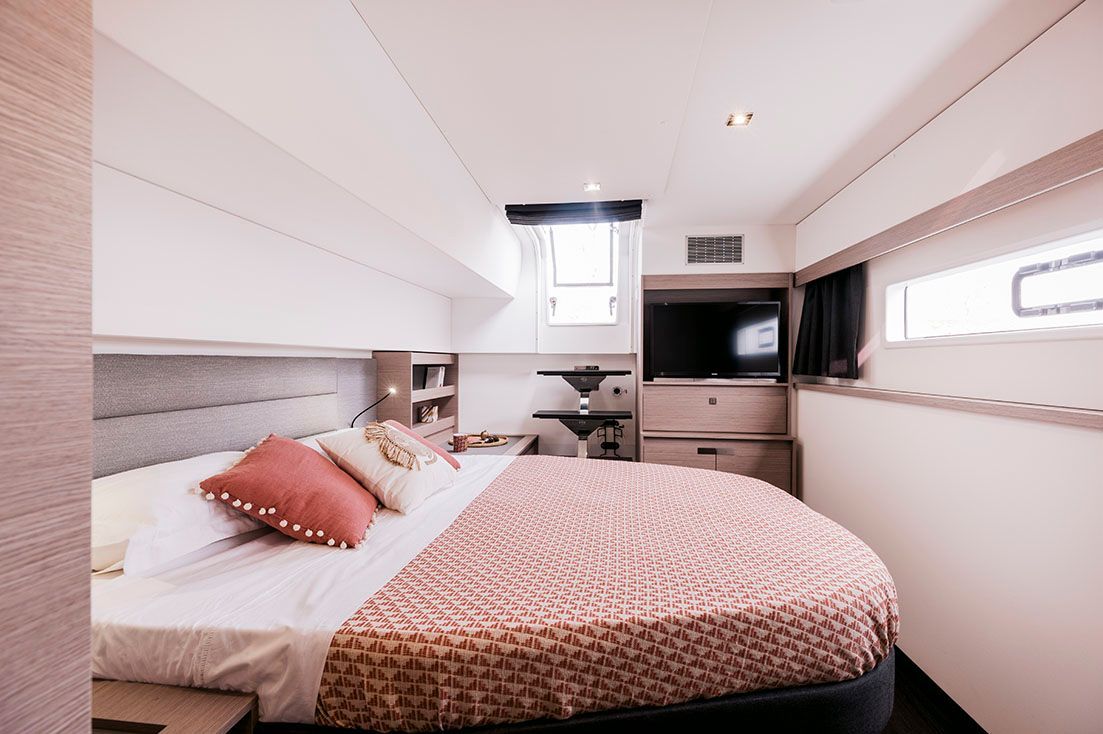 a bedroom on a boat with a round bed and a television