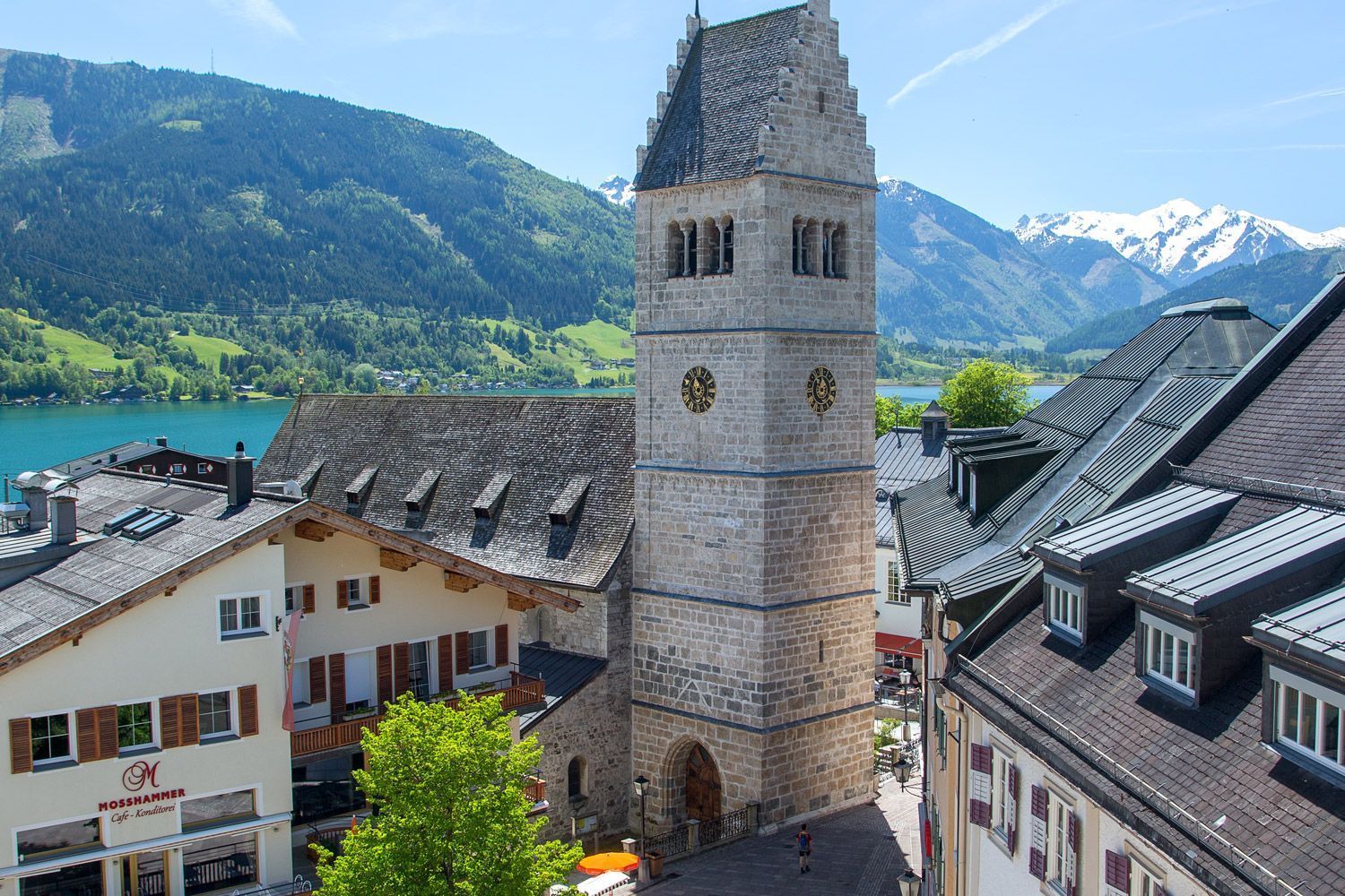 an aerial view of a city with a clock tower and mountains in the background