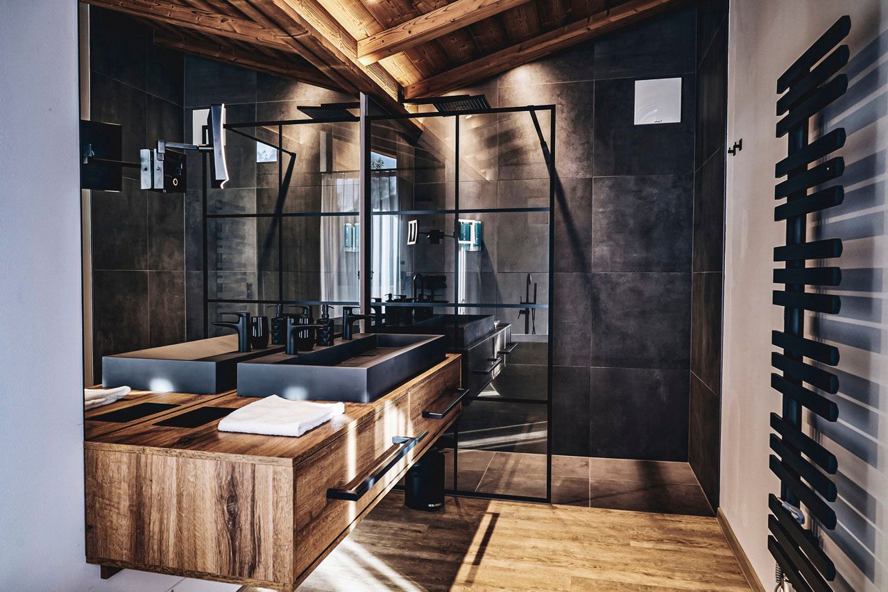 a bathroom with two sinks and a walk in shower
