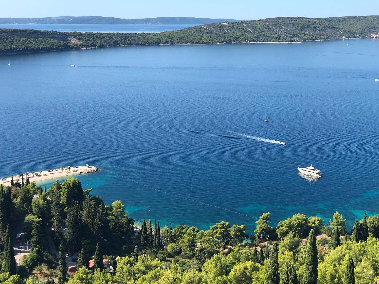 a boat is floating on top of a large body of water surrounded by trees