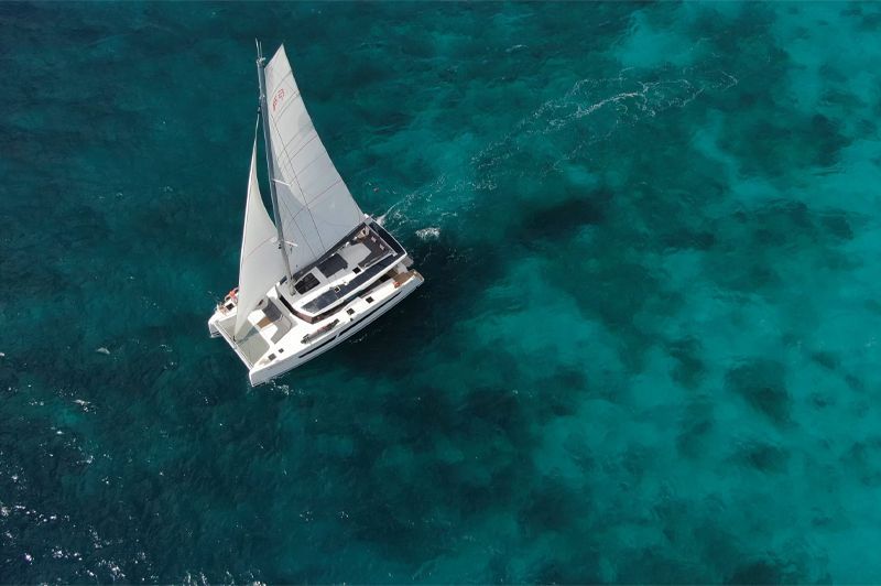 an aerial view of a sailboat in the ocean .