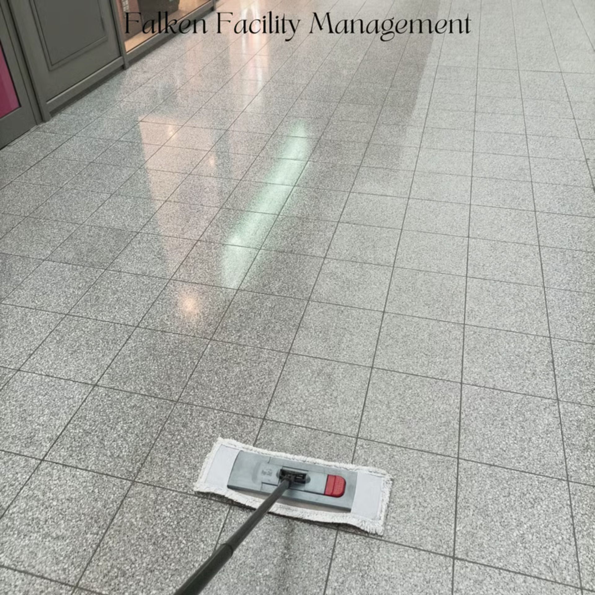Wischmopp reinigt grauen Fliesenboden in einem gewerblichen Umfeld.