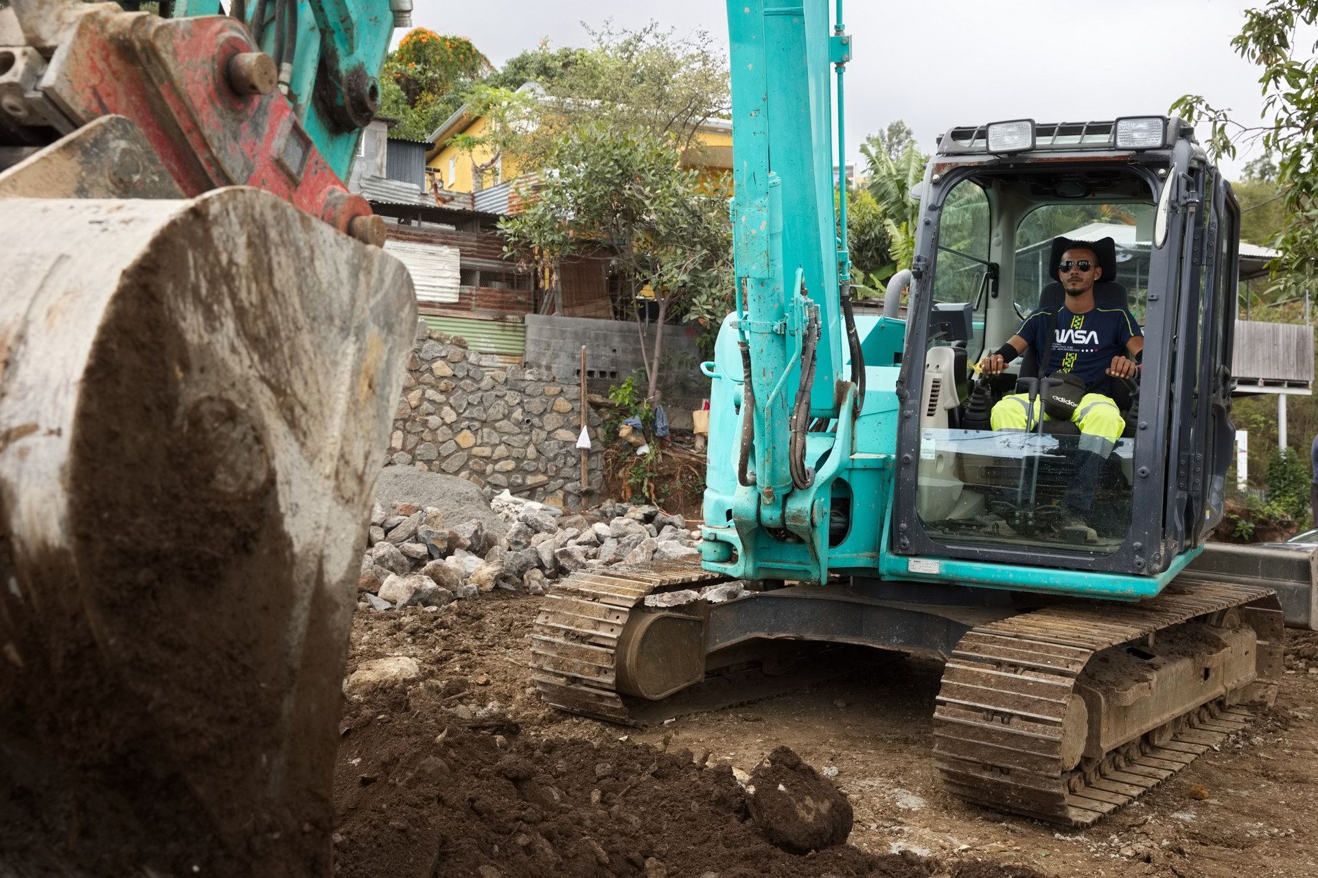 Conducteur d'une minipelle en train de terrasser