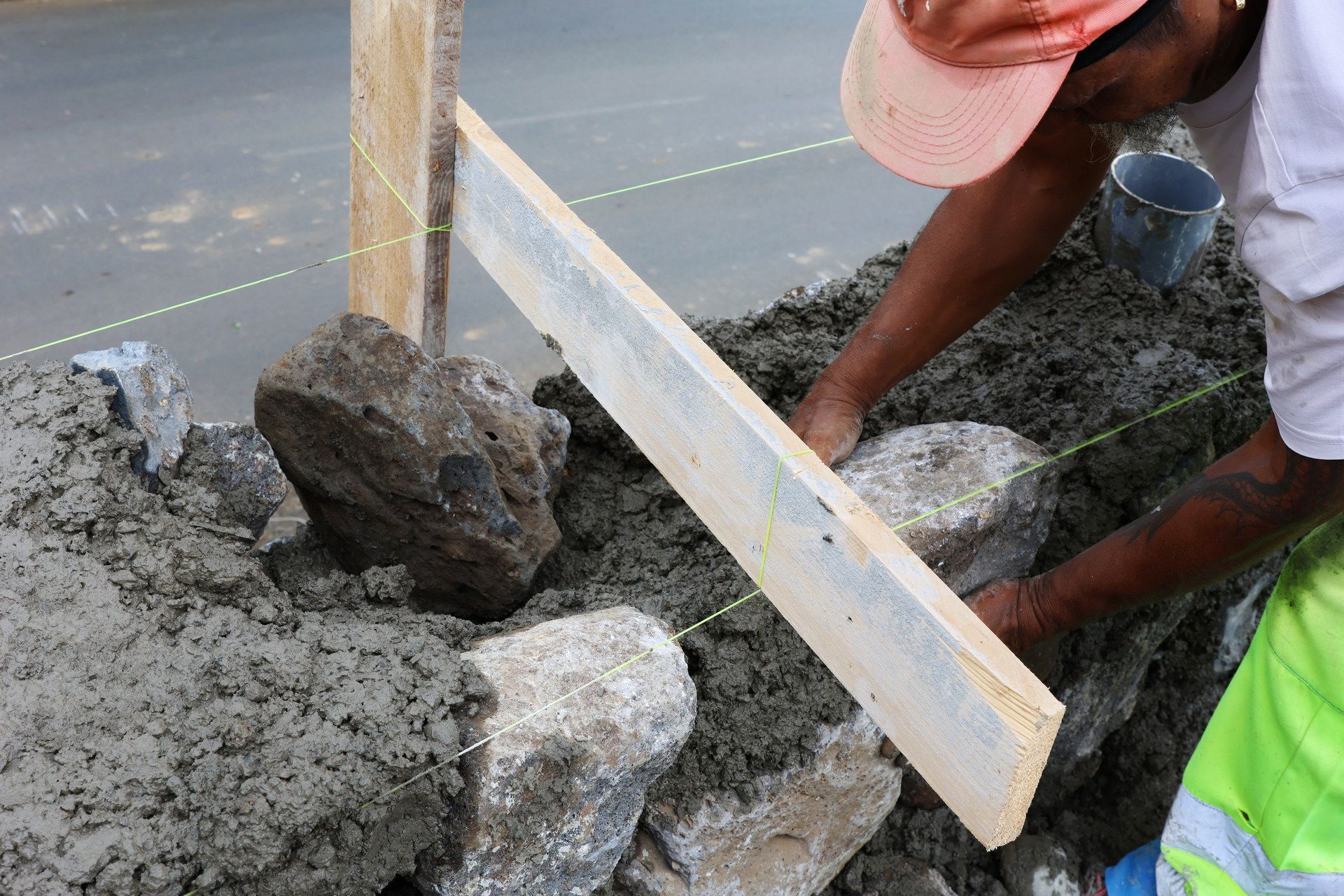 Ouvrier réalisant un mur de clôture en moellons