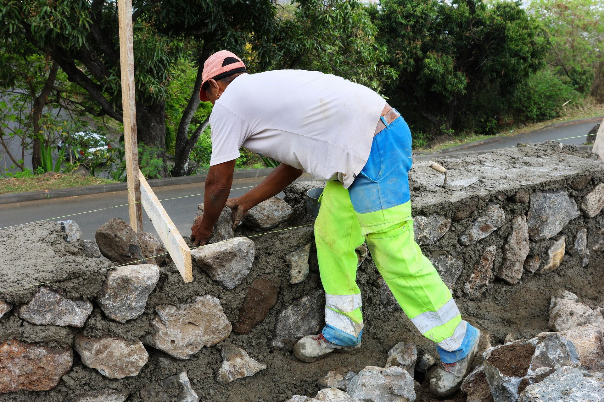 Ouvrier réalisant un mur en moellons