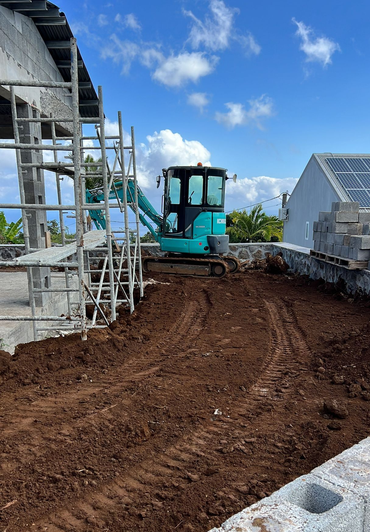 Mini-pelle bleue effectuant du terrassement