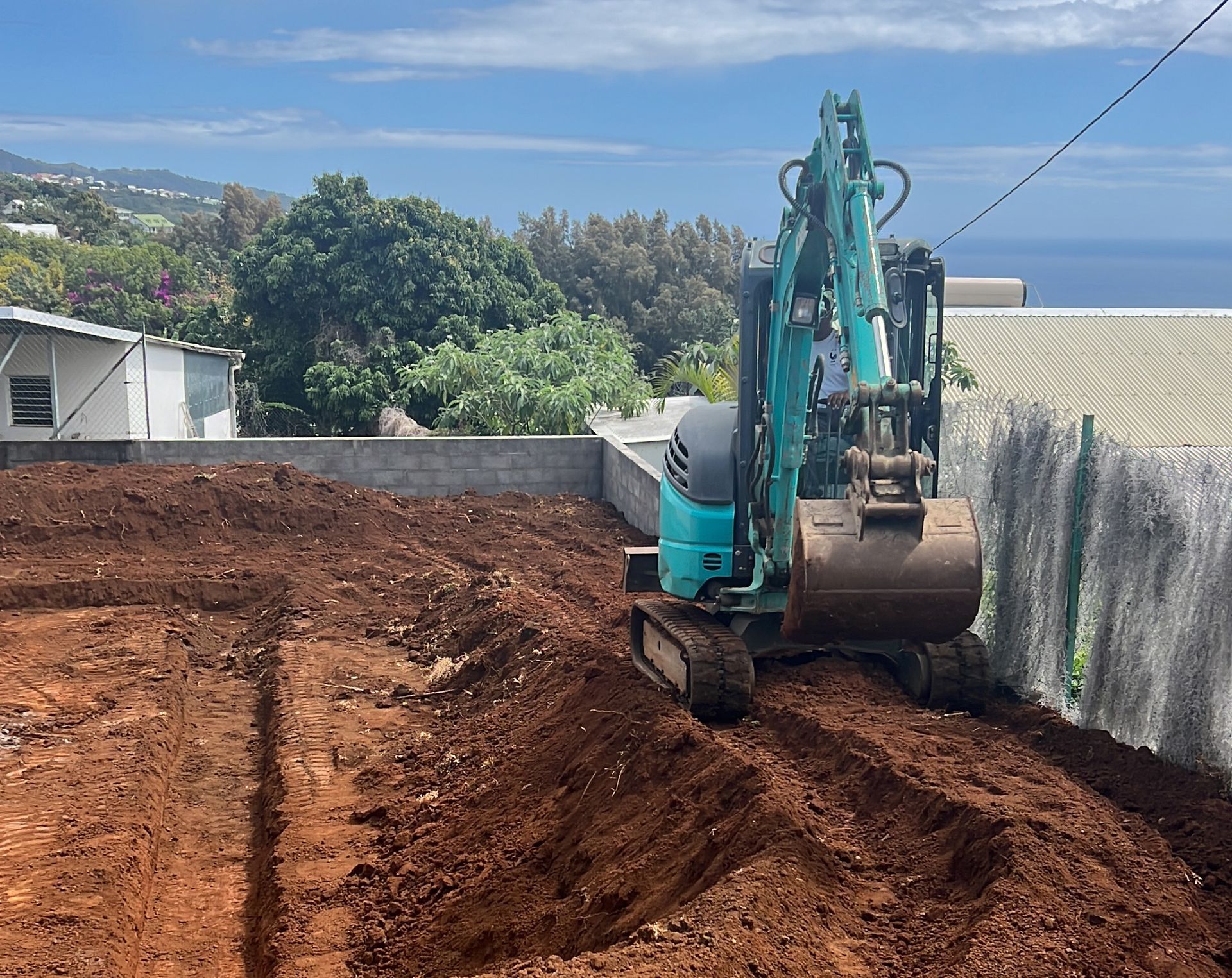 Pelleteuse bleue en train de travailler la terre sur un terrain