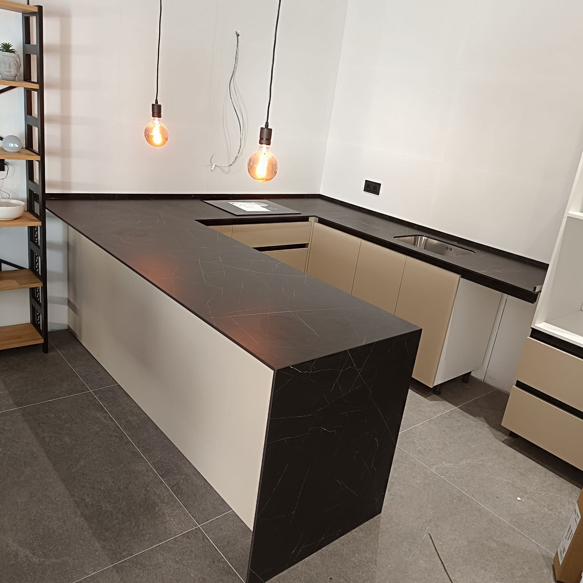 Una cocina con gabinetes blancos, encimeras de mármol y un fregadero.