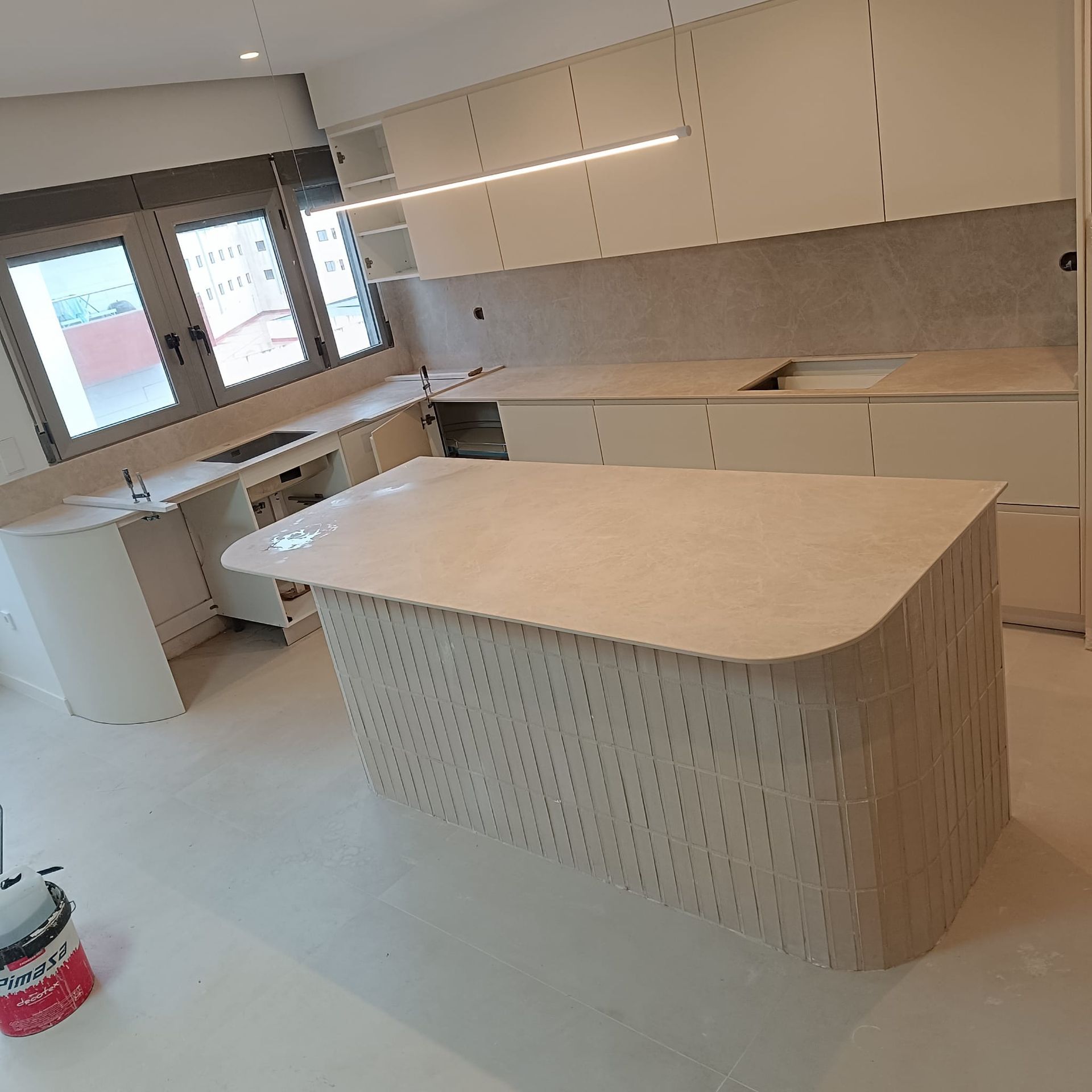 Una mesa de madera está colocada en una habitación al lado de una ventana.
