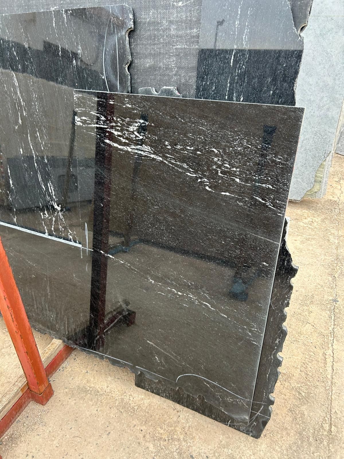 Una losa de granito negro reposa sobre un soporte de madera.