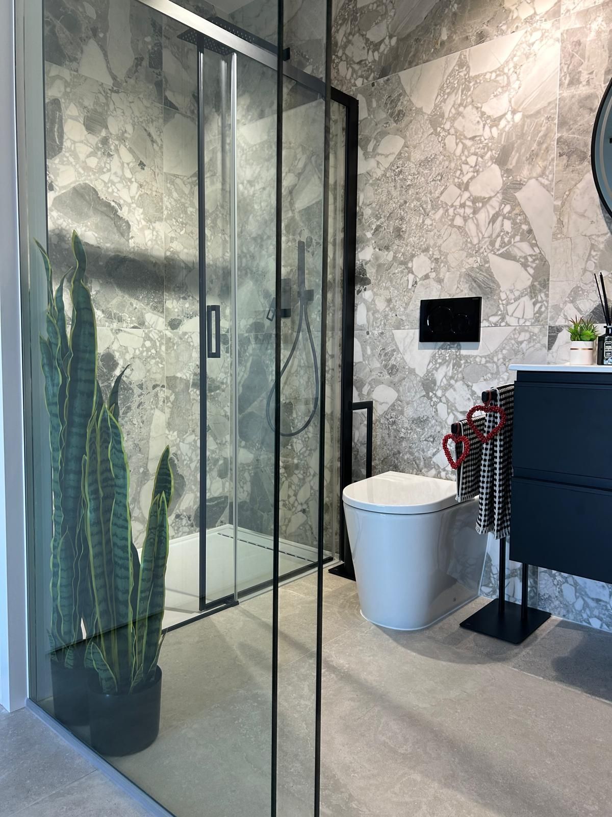 Un baño con inodoro, lavabo, ducha y espejo.