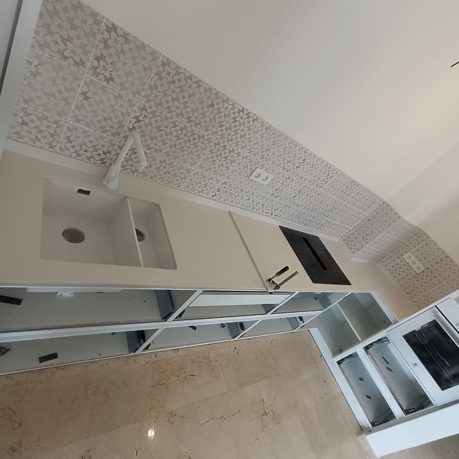 Una cocina con encimeras de mármol y gabinetes de madera.