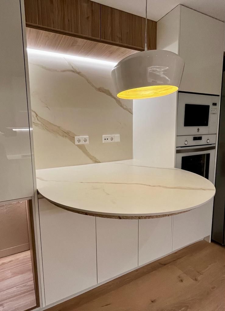 Una cocina con una mesa redonda y una luz amarilla colgando del techo.