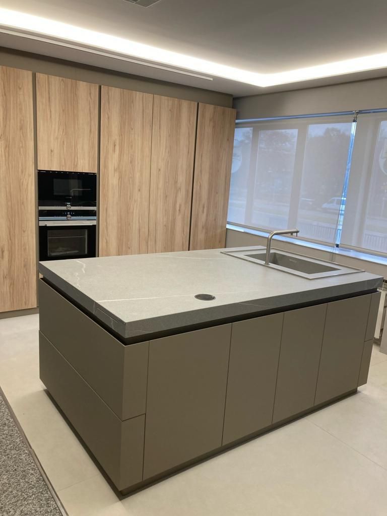 Una cocina con una gran isla y un fregadero.