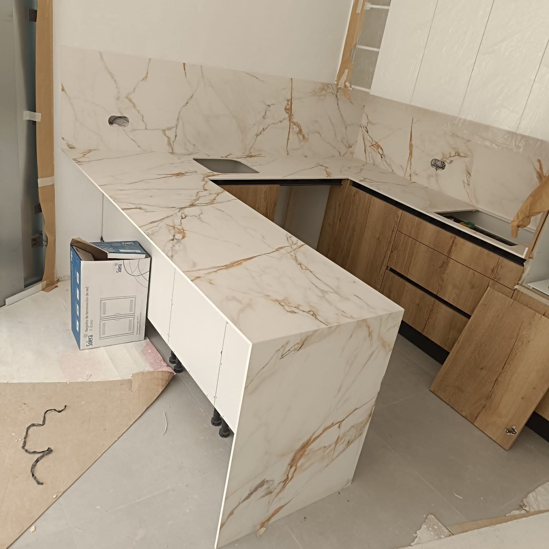 Una cocina con encimeras de mármol y gabinetes de madera.