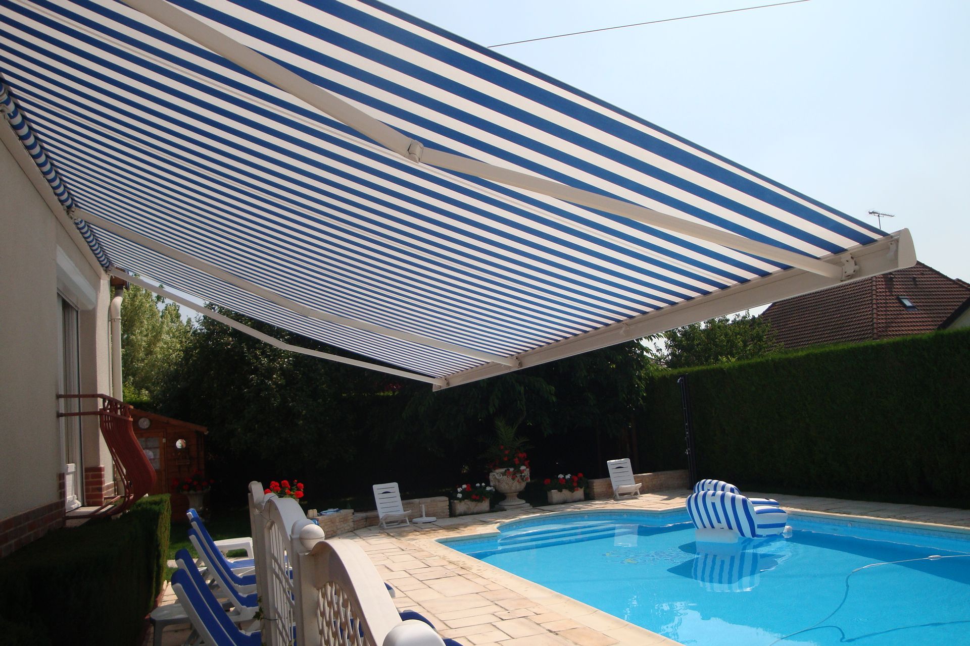 Un store banne de terrasse avec une piscine.