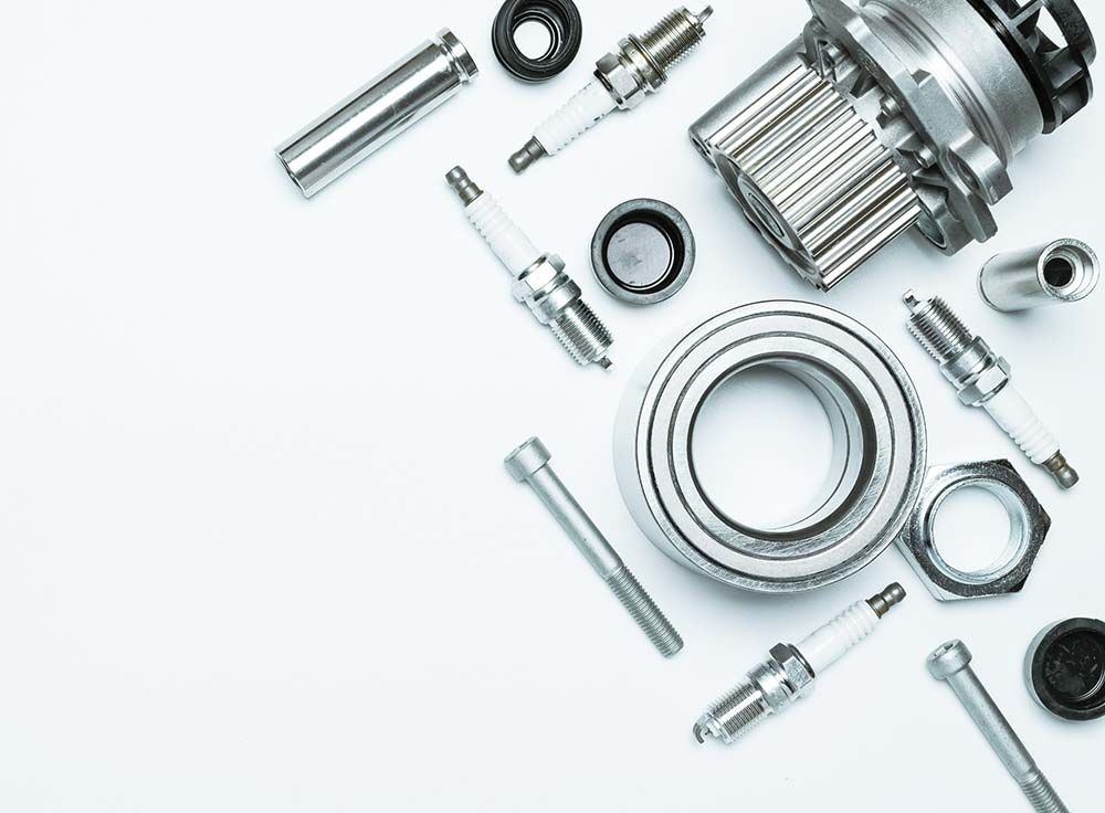 Un montón de piezas de automóvil se encuentran sobre una superficie blanca.