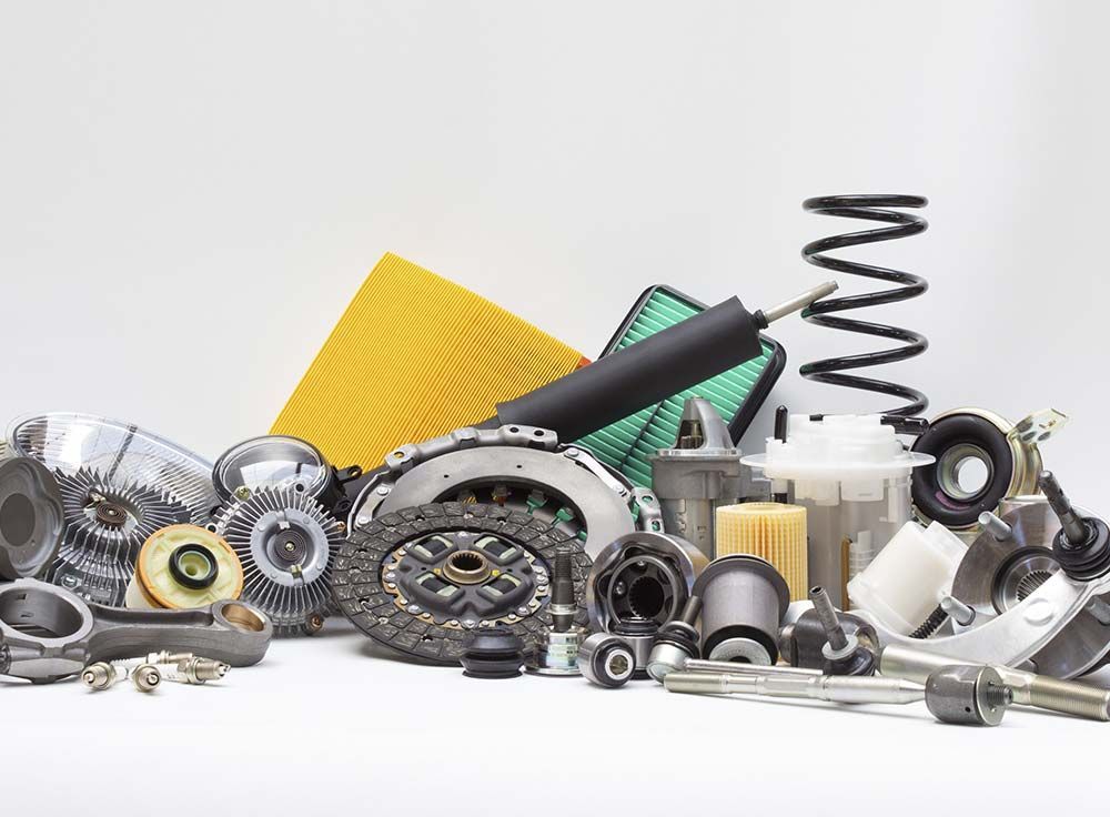 Un montón de piezas de coche sobre una superficie blanca.