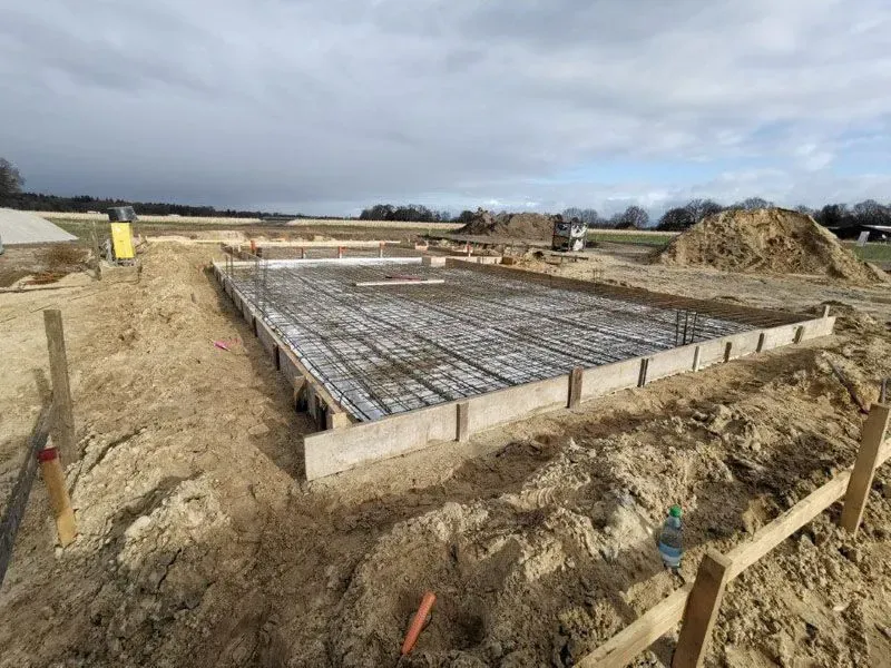 Auf einem Feld wird ein Betonfundament gebaut.