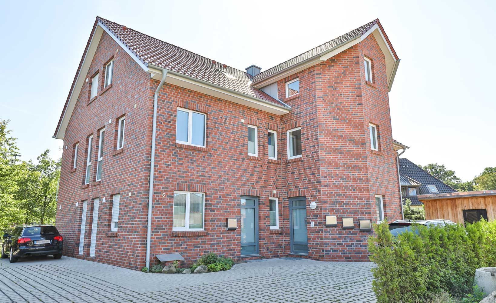 Ein großes Backsteingebäude mit einem davor geparkten Auto.