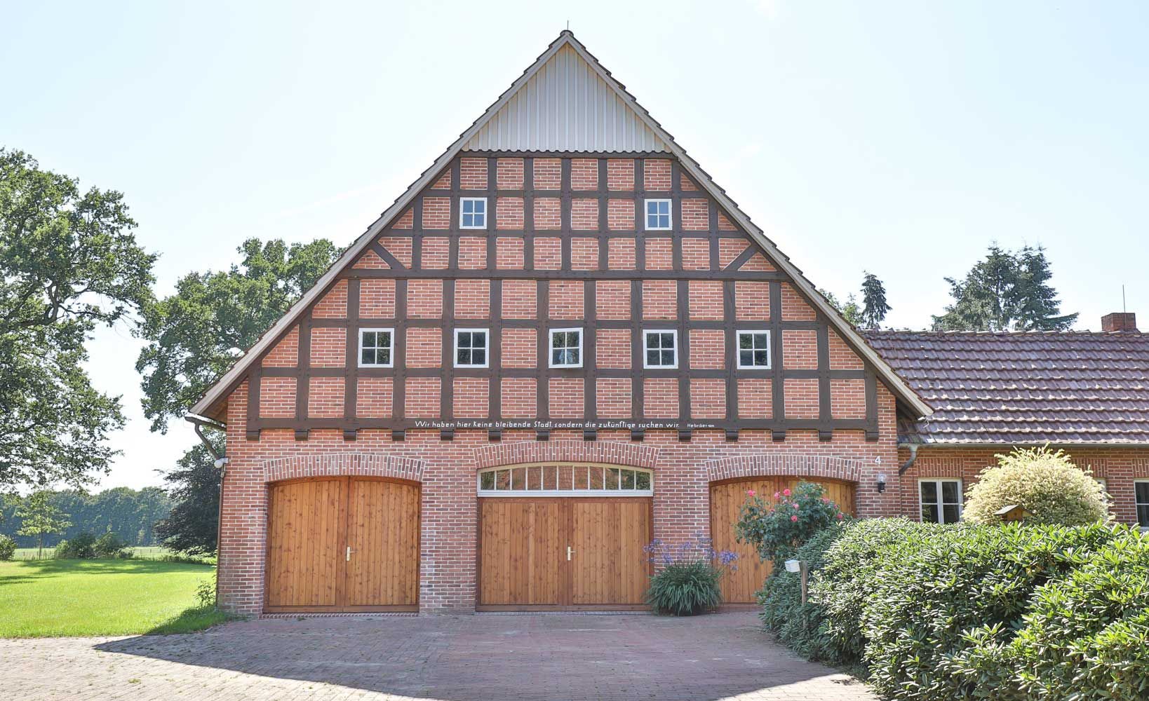 Ein großes Backsteingebäude mit hölzernen Garagentoren