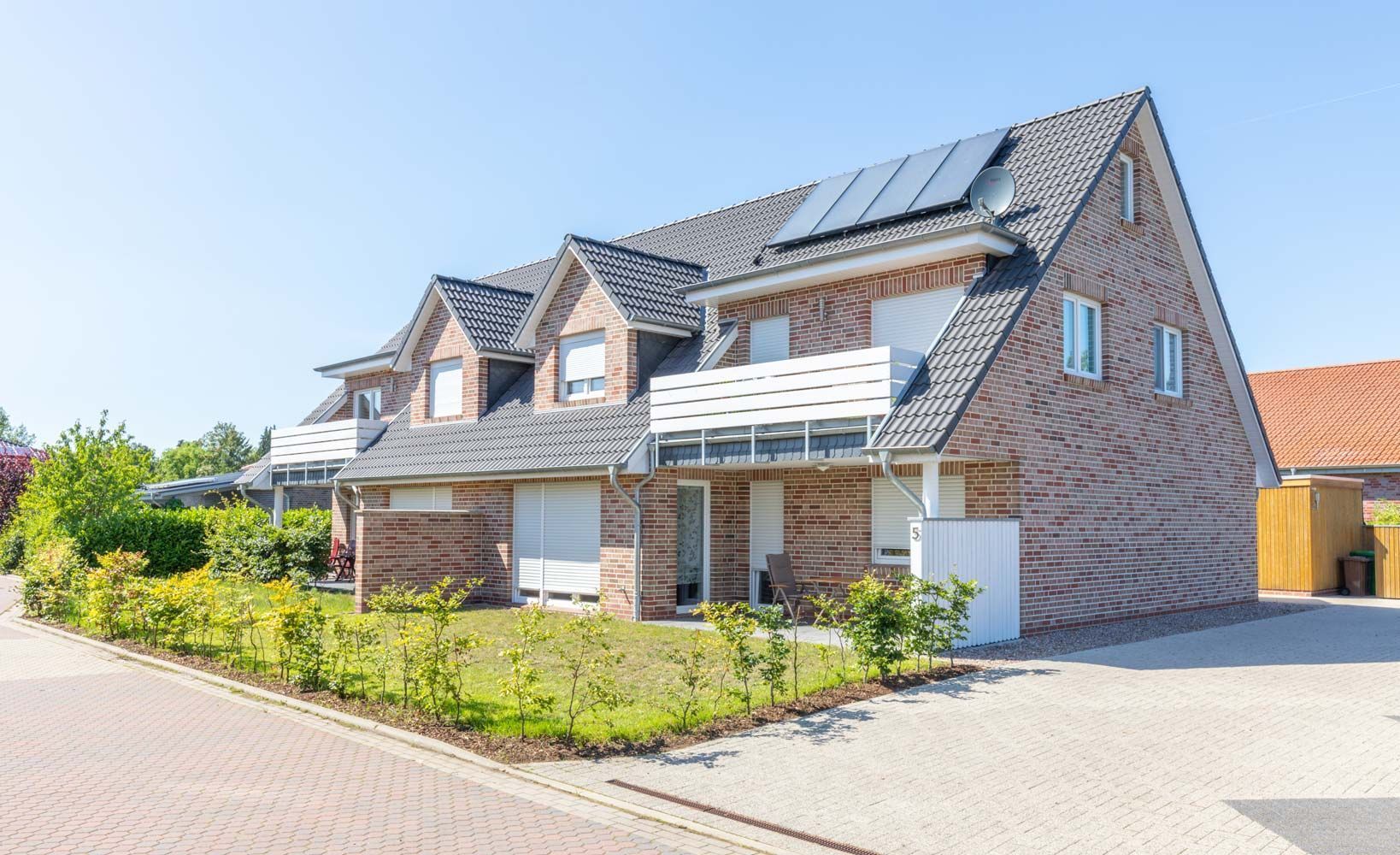 Ein großes Backsteinhaus mit Sonnenkollektoren auf dem Dach.