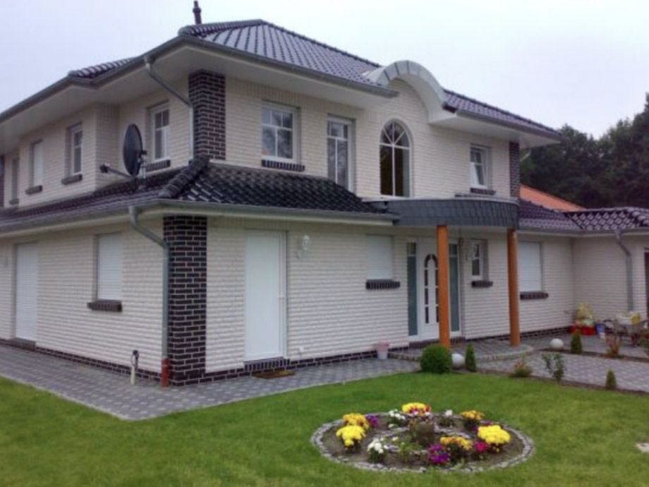 Ein großes weißes Haus mit einem schwarzen Dach