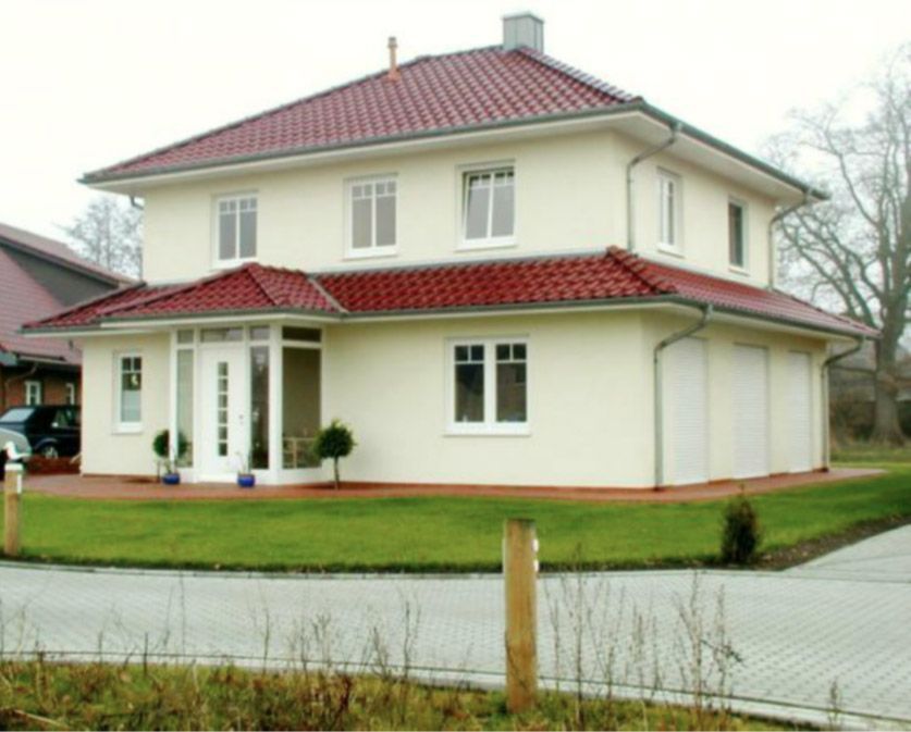 Ein großes weißes Haus mit einem roten Ziegeldach