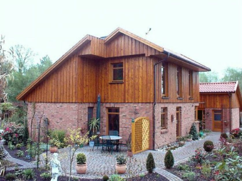 Ein Backsteinhaus mit Holzdach und Terrasse