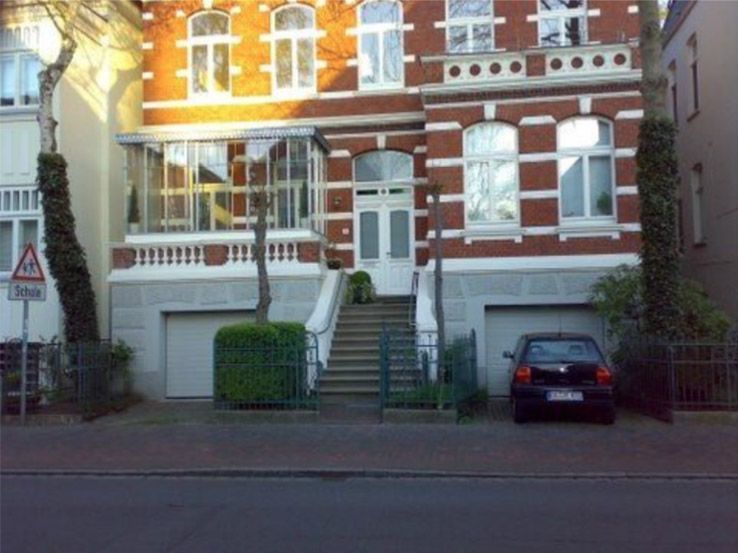 Ein Auto steht vor einem großen Backsteingebäude