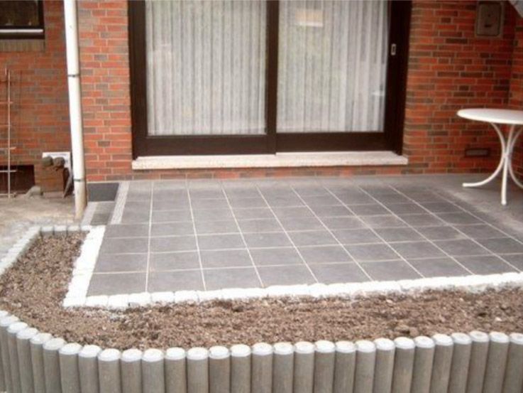 Ein Backsteinhaus mit einer Terrasse und einem Tisch