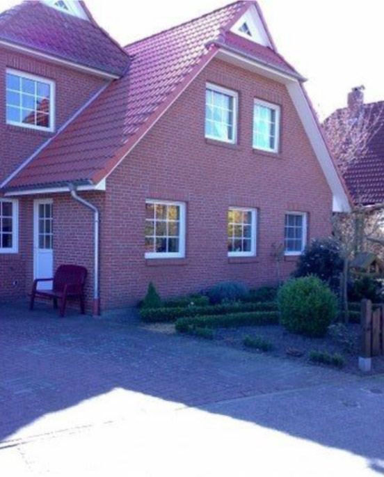 Ein Backsteinhaus mit einem violetten Dach und weißen Fenstern