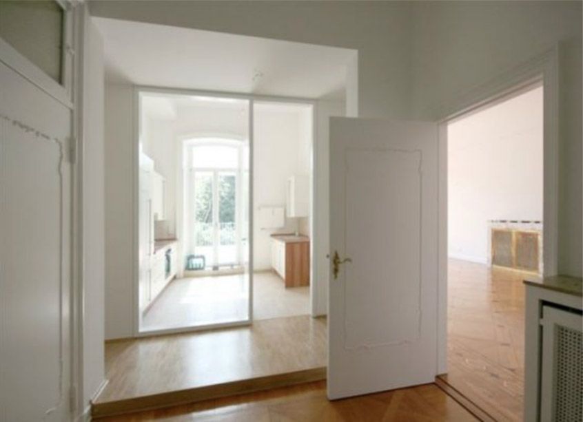 Ein Flur, der zu einer Küche mit einer Glasschiebetür führt