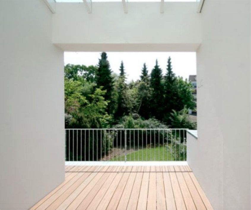 Ein Balkon mit Geländer und Bäumen im Hintergrund